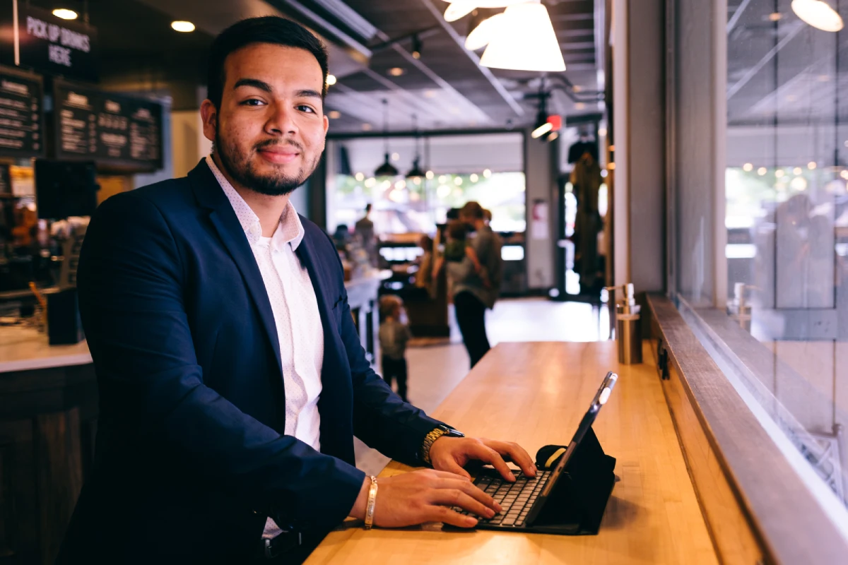 Graduate student working on tablet in coffee shop