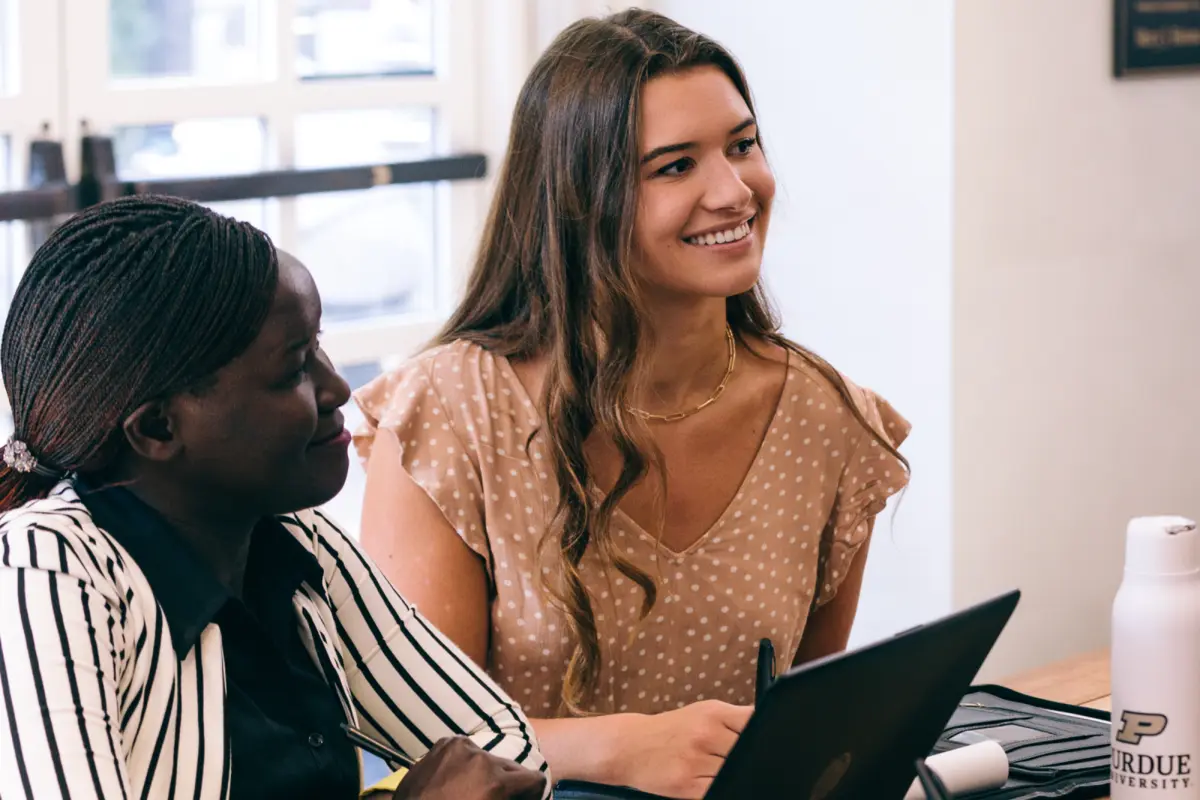 Smiling graduate student collaborates with peers