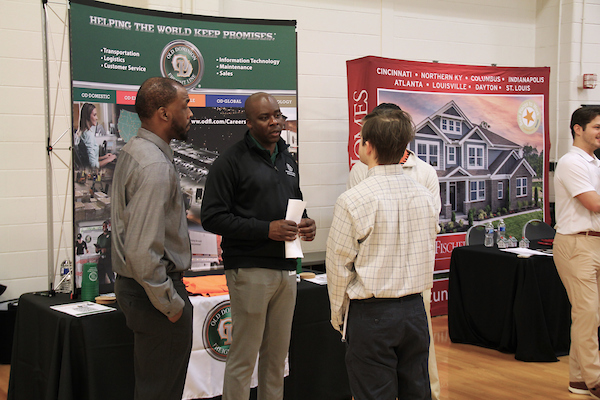 Student talks to recruiter at a career fair booth.