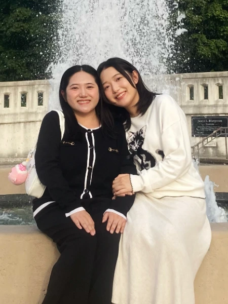 Two sisters sit together and smile in front of a large outdoor fountain on Purdue University’s campus. One gained human resources experience by helping her team win the HR Case Competition in 2026.