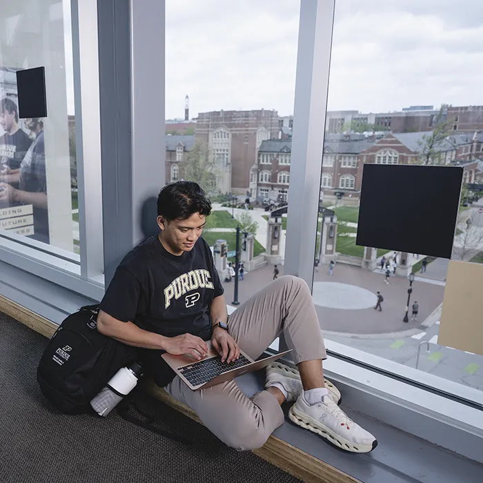 Chana Batan sitting in the skywalk overlooking campus
