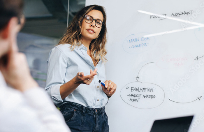 Speaker providing details on whiteboard to colleagues