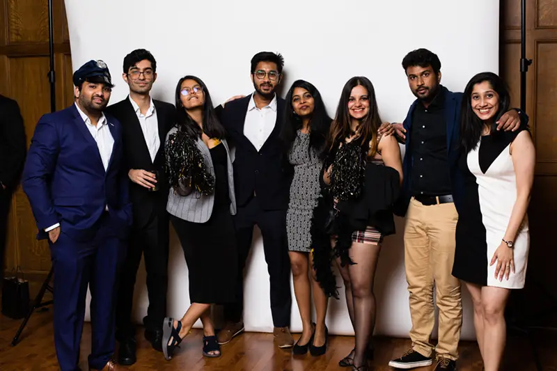Eight students pose for a photo at a party