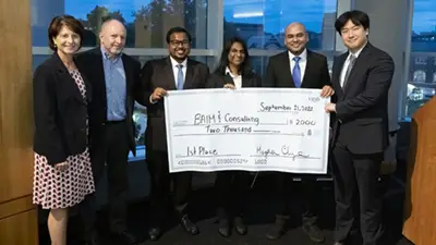 Students present the winnings from their case competition victory