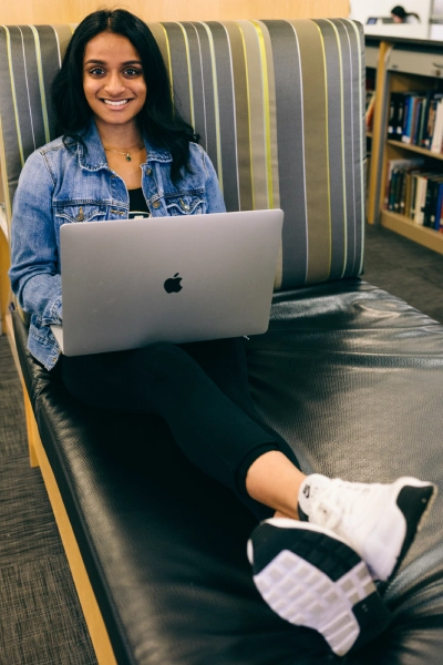 Smiling student Diya Thomas with laptop