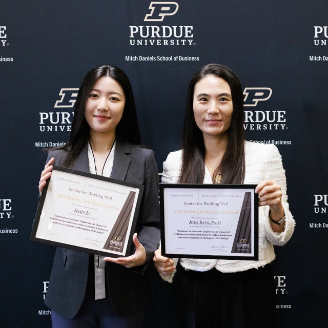 Jiarui Li and Jiyun Kang holding award