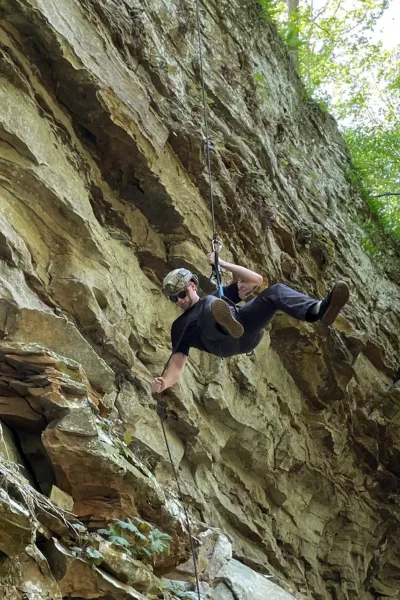 Michel rappelling down a rock face