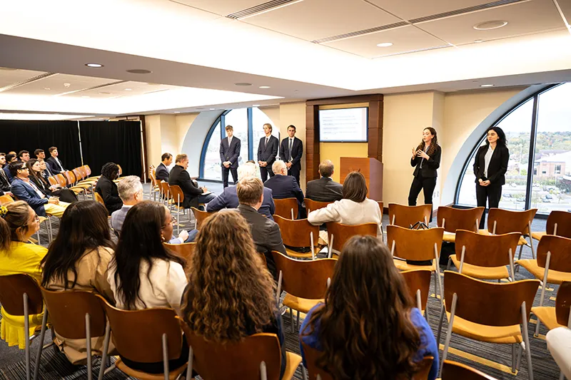 Group of tudents standing in front of a sculpture