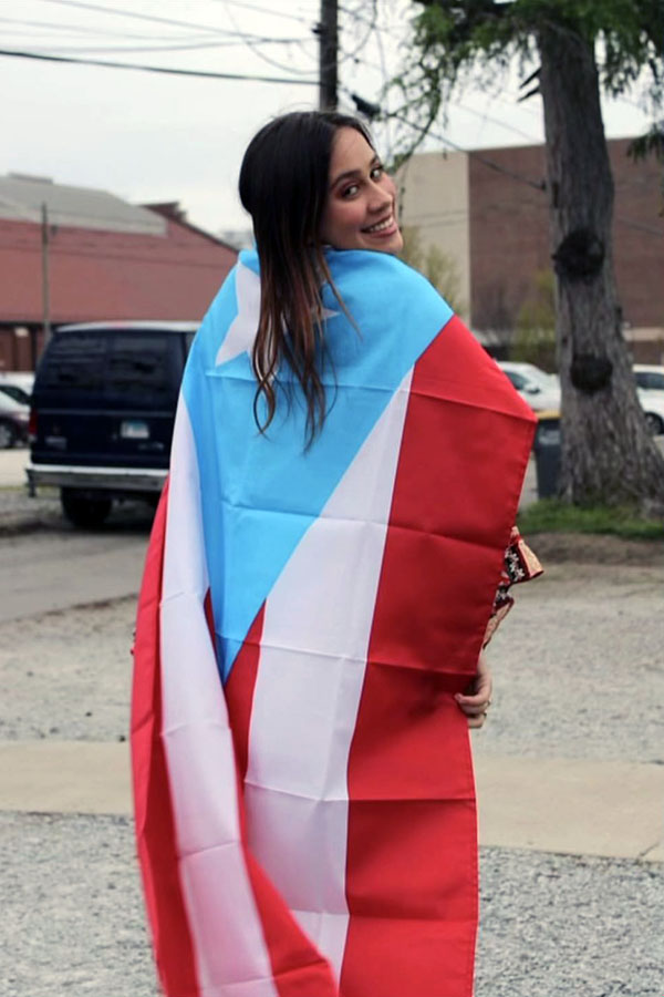 Ana stands with a Puerto Rican flag
