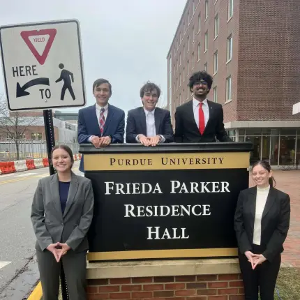 Ryan Mooney and the Frieda Consulting Council posing outside the Frieda Parker Residence Hall.