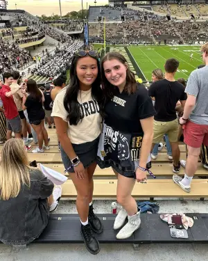 Lia cheering on the Purdue football team with a friend