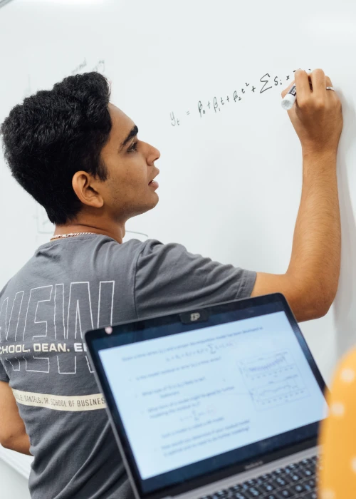 Student writing equation on board