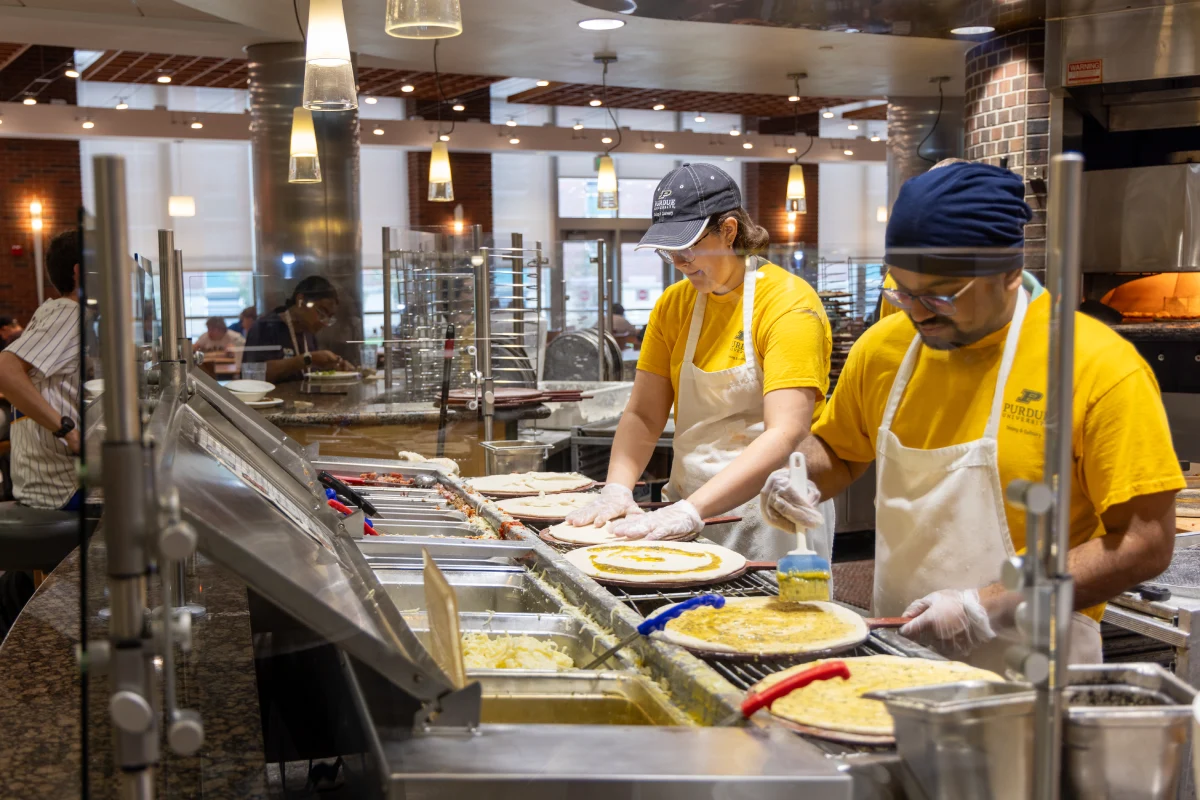 Workers preparing pizza