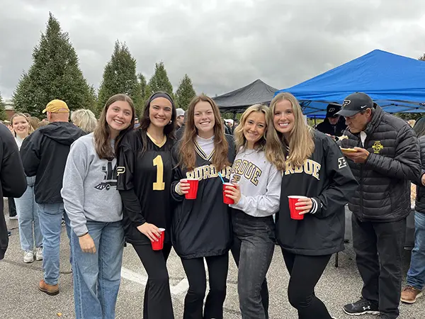 Bella (middle) with friends at a tailgate in the Co-Rec parking lot