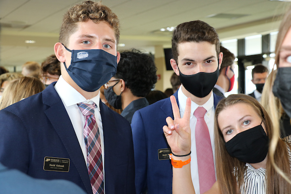 Students smile behind masks for the camera